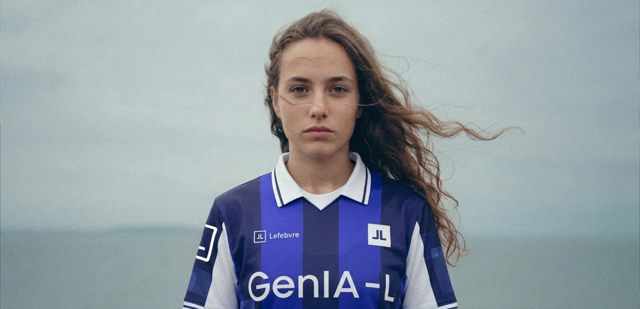 Retrato de una joven con la camiseta GenIA-L frente al mar, con el pelo al viento